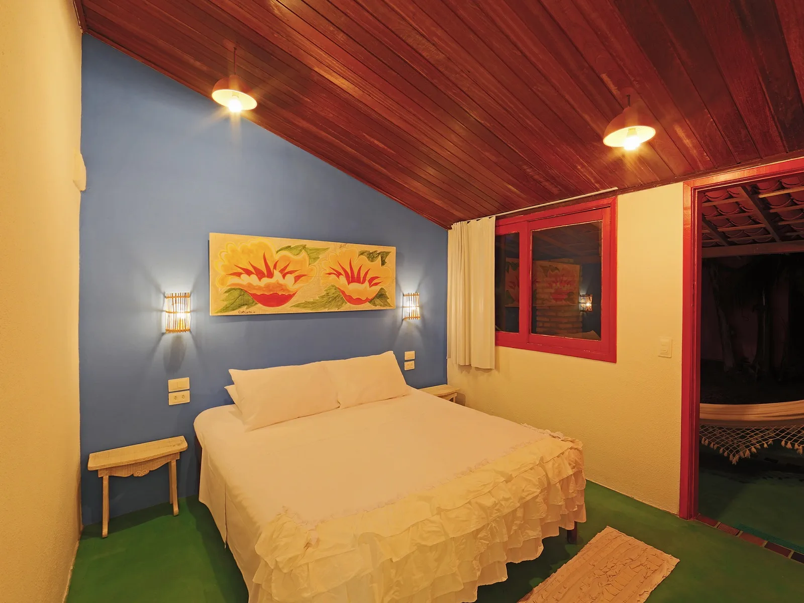Duplo Econômico Lateral Mar, quarto com parede azul, arte floral regional, cama de casal e vista para a varanda com rede