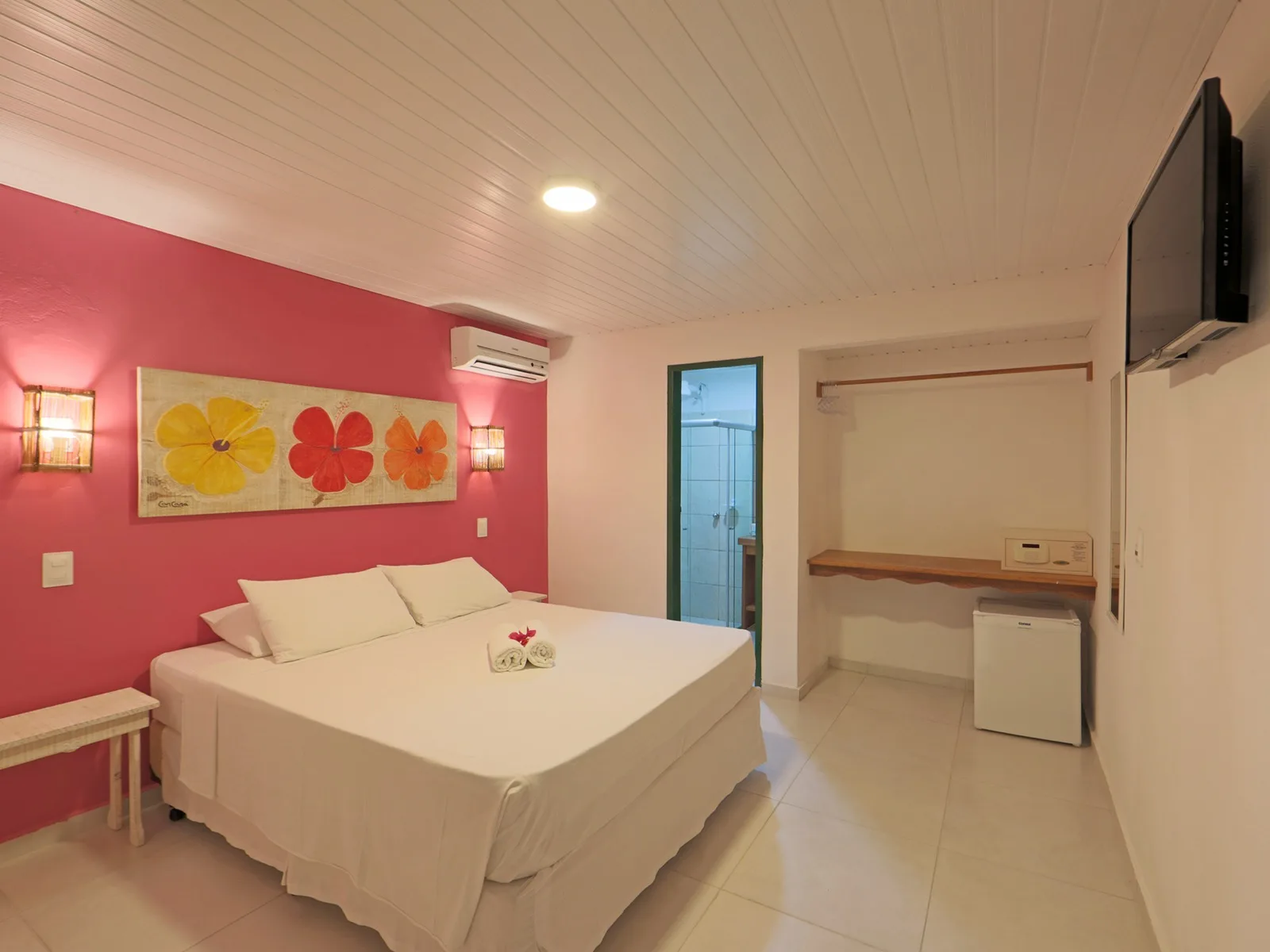 Econômico Sem Vista Mar, quarto de casal com parede pink, quadro de três hibiscos e cama de casal