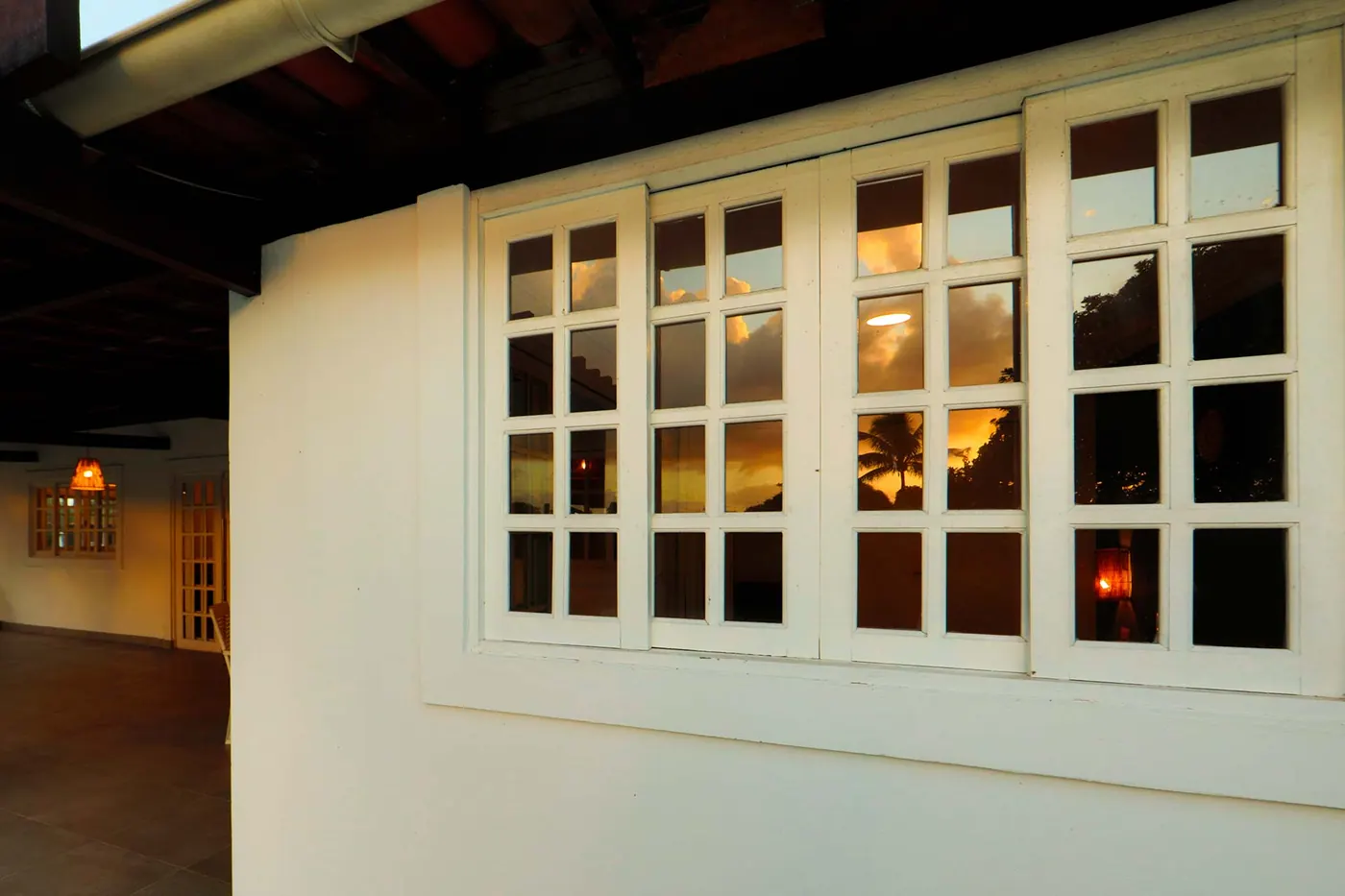 Villa com Piscina Privativa — janelas refletindo o entardecer