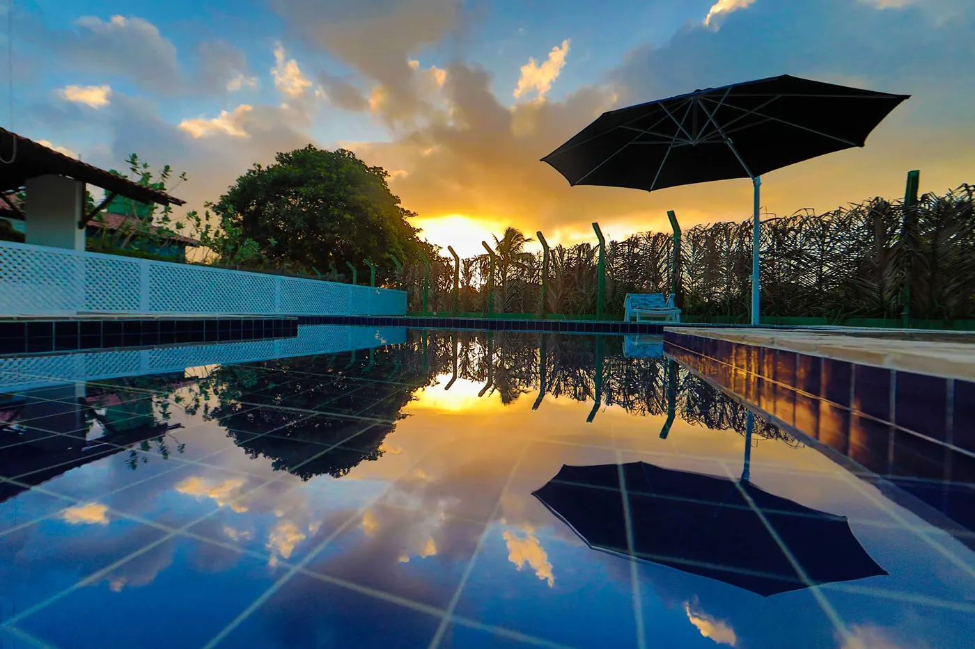 Villa com Piscina Privativa — piscina refletindo o pôr do sol
