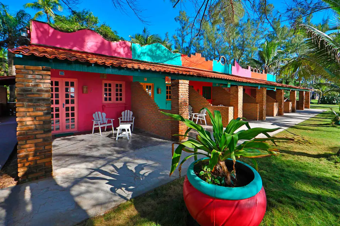 Duplo Econômico Vista Mar — fachada colorida entre coqueiros