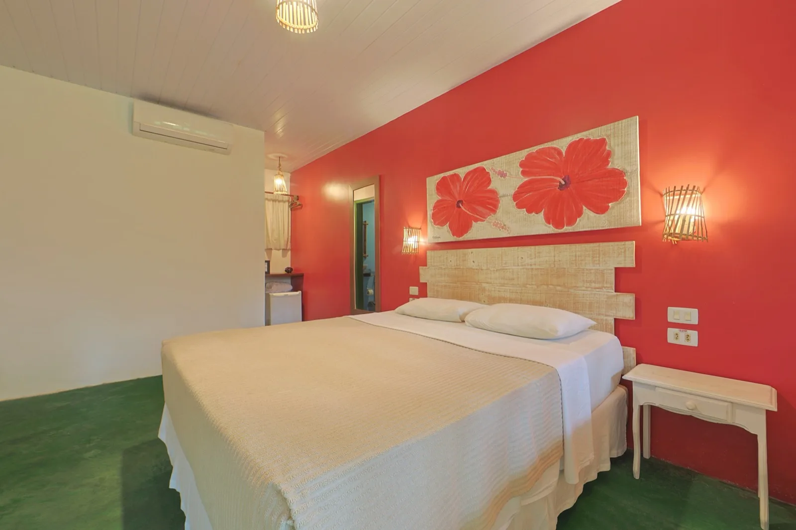 Família Lateral Mar, suíte com parede vermelha, painel de hibiscos e cama de casal