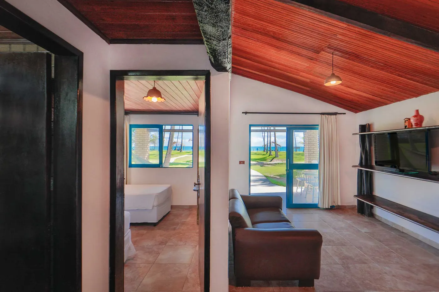 Vista da sala em direção ao quarto e à porta para o jardim e o mar