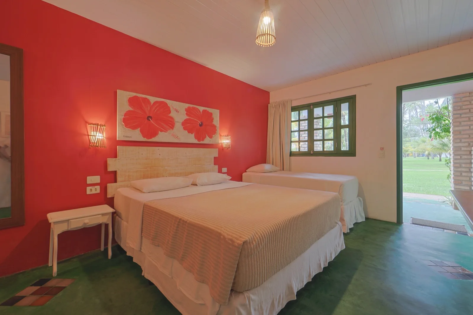 Família Lateral Mar, quarto com parede vermelha, painel de hibiscos e cama de casal com cama de solteiro