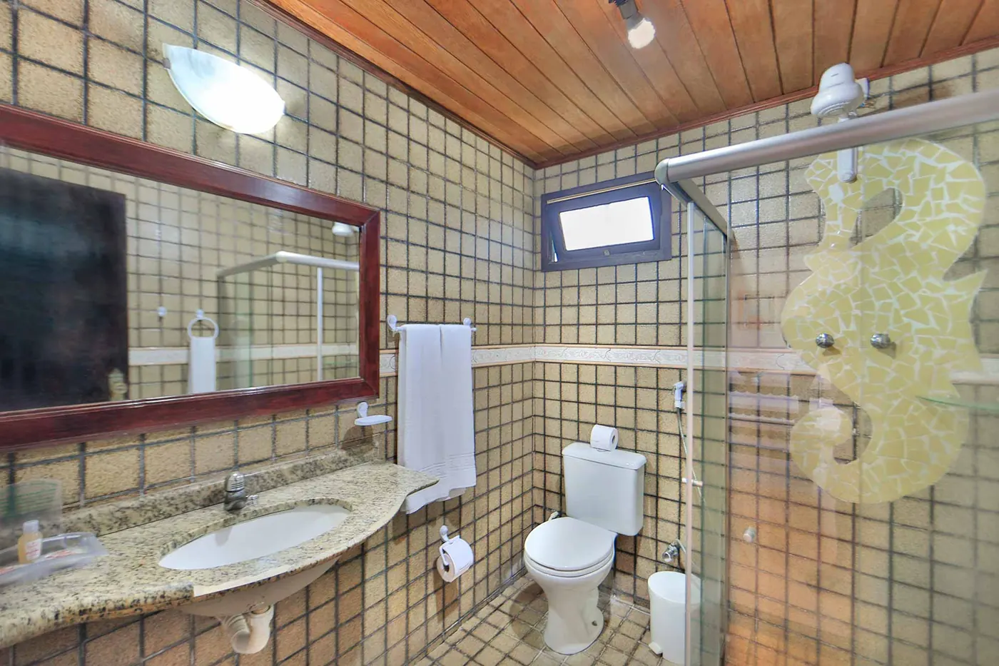 Segundo banheiro com bancada em granito e mosaico decorativo de cavalo-marinho