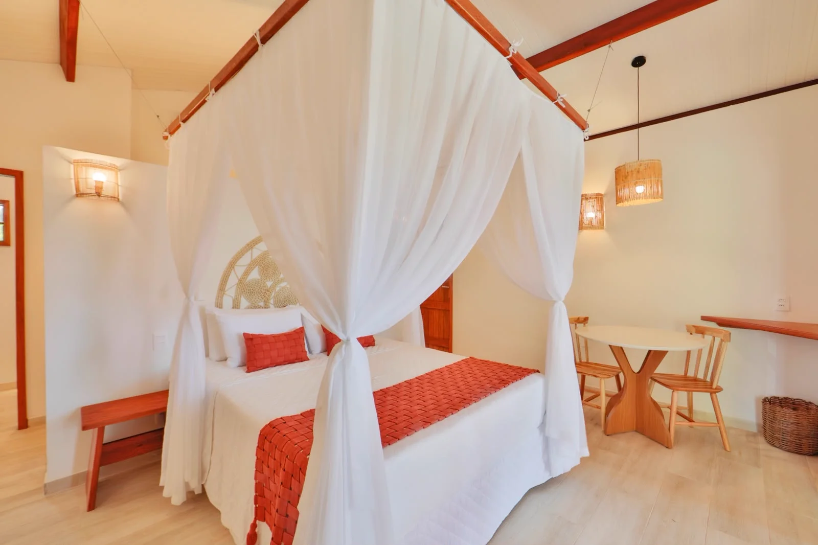 Bangalô Duplo Vista Parcial do Mar — quarto com cama de dossel e travesseiros coral