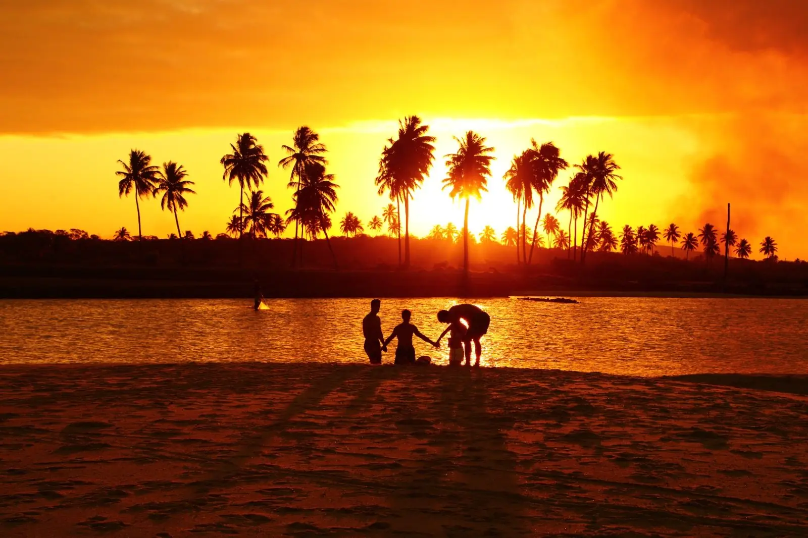 Pôr do sol com silhuetas na praia