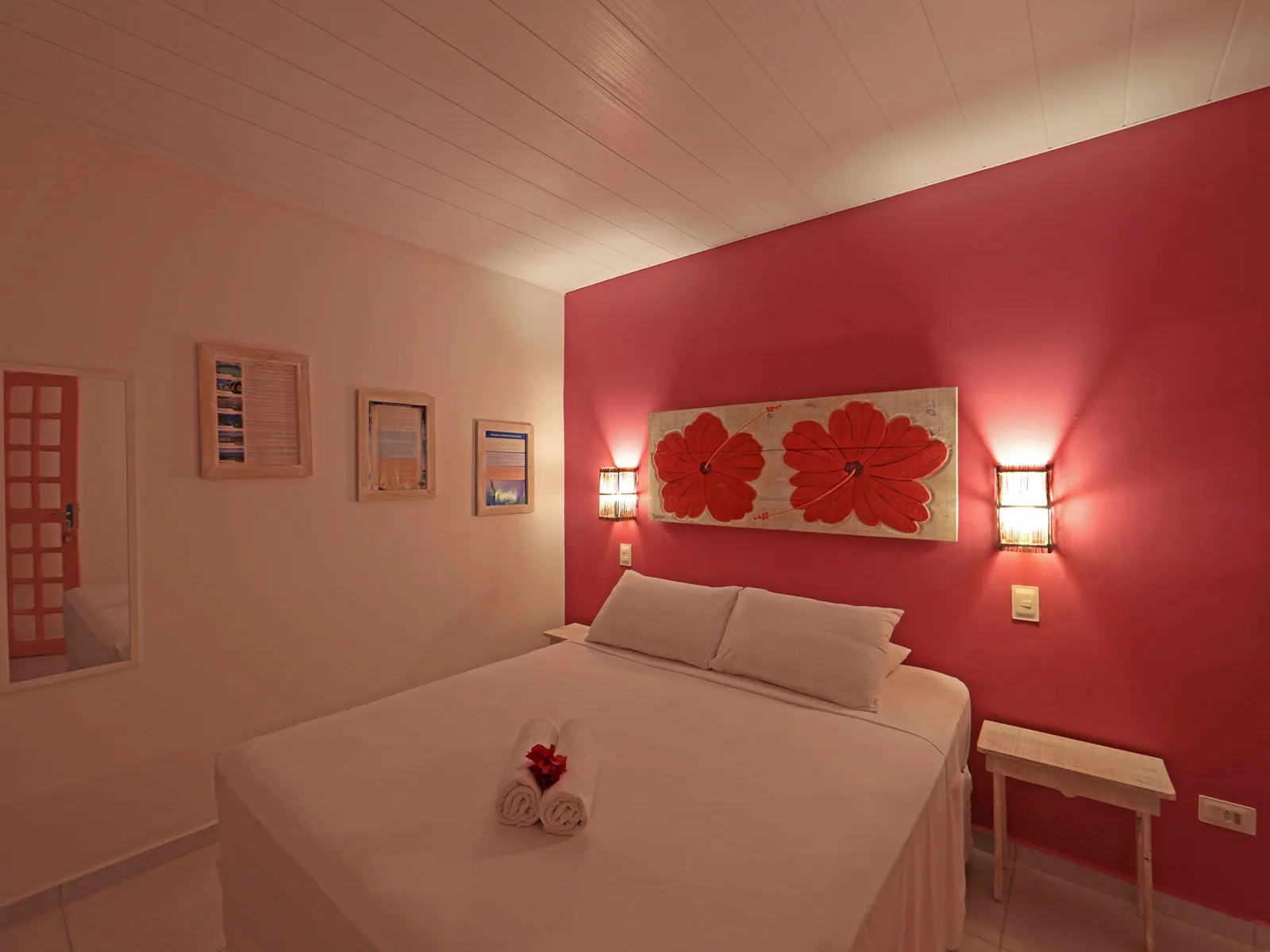 Duplo Econômico Vista Mar, quarto vermelho com painel floral sobre a cama